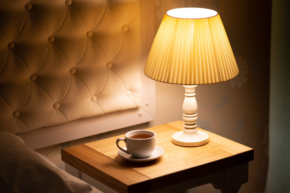 Persona che legge a letto con l'aiuto di una lampada